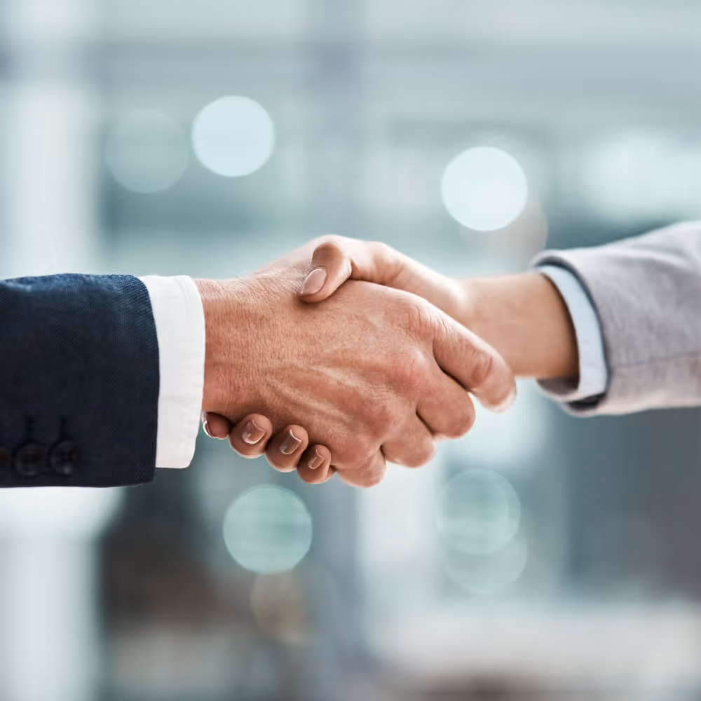 Close-up of two people shaking hands, symbolizing agreement or partnership.